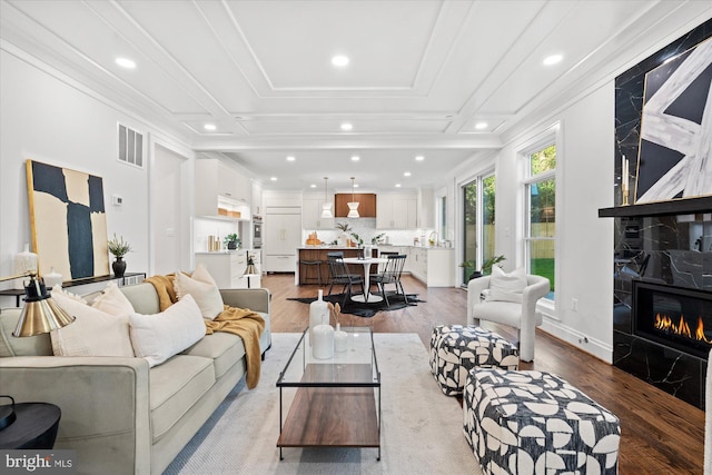 spare room with a notable chandelier, plenty of natural light, light hardwood / wood-style floors, and ornamental molding