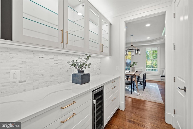 bar featuring gray cabinetry, stainless steel oven, sink, light hardwood / wood-style floors, and beverage cooler