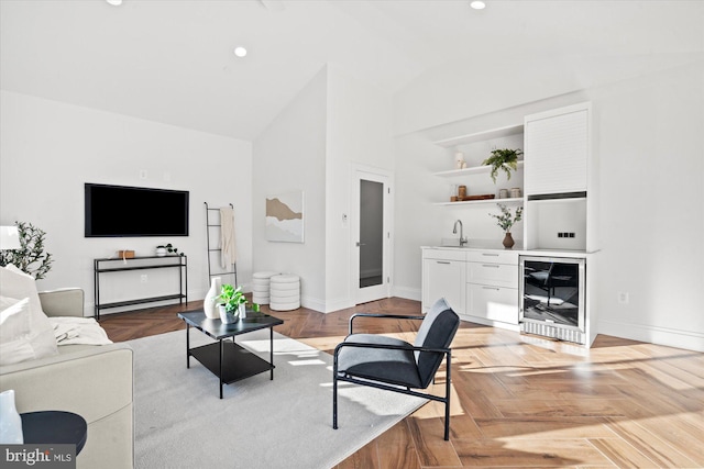 living room with high vaulted ceiling, light parquet floors, beverage cooler, and sink