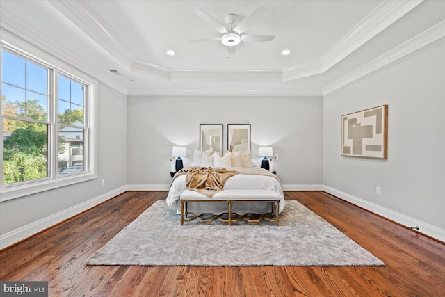 bedroom featuring dark hardwood / wood-style floors, a raised ceiling, and ceiling fan