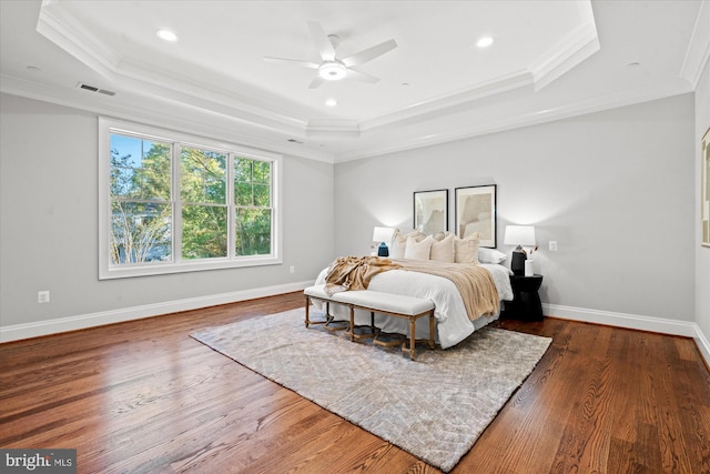 bedroom featuring a raised ceiling, ceiling fan, dark hardwood / wood-style flooring, and ornamental molding