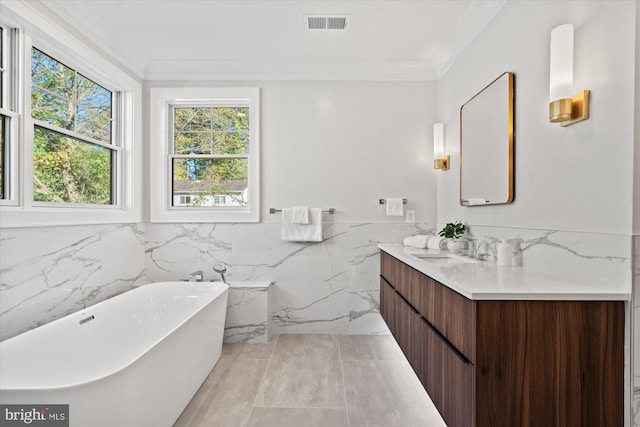 bathroom featuring vanity, a tub to relax in, ornamental molding, and tile walls