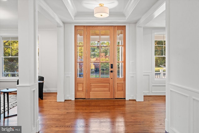 living room with crown molding, wooden walls, and light hardwood / wood-style floors