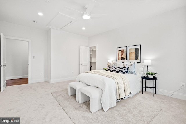 carpeted bedroom with ceiling fan and a spacious closet