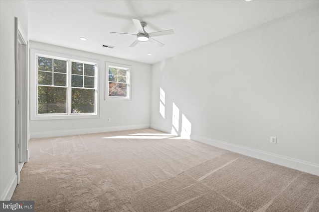 spare room featuring ceiling fan and light colored carpet