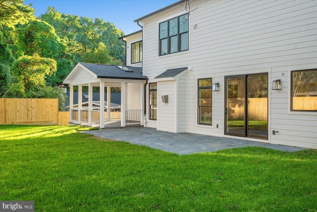 back of property featuring a yard, a hot tub, and a patio area