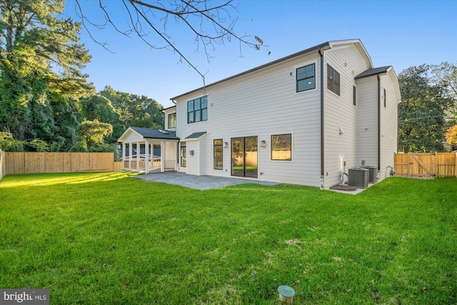 rear view of property featuring a lawn, a patio area, and cooling unit