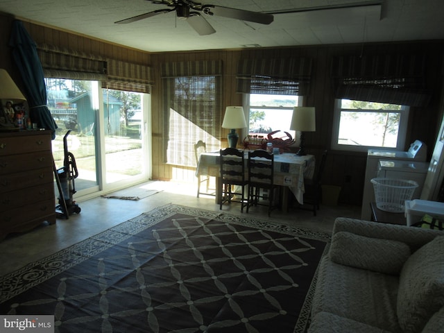 living room featuring wood walls and ceiling fan