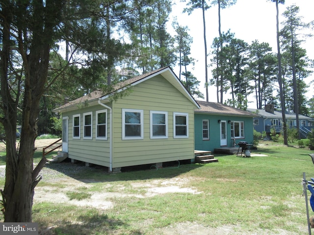 rear view of property featuring a lawn