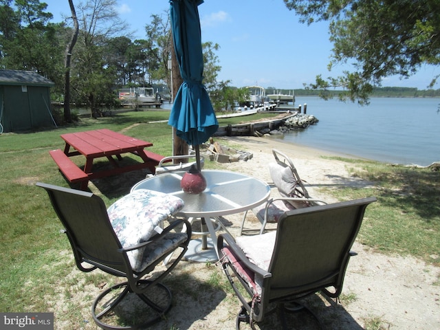 view of patio with a water view and a boat dock