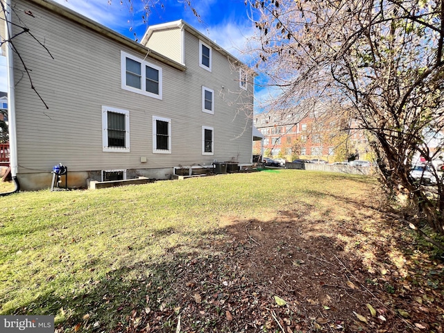 rear view of house featuring a yard and central AC unit