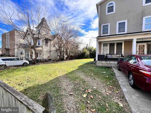 view of side of home with a porch and a yard