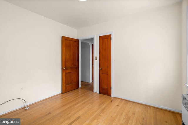 empty room featuring light hardwood / wood-style floors and radiator heating unit