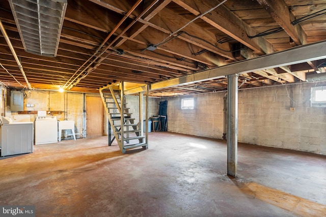 basement with washing machine and dryer, sink, and electric panel