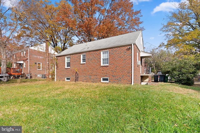 view of side of property with a lawn and central AC