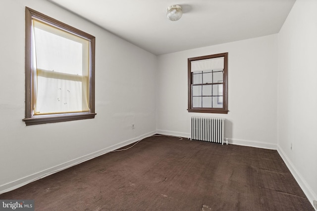 carpeted empty room featuring radiator