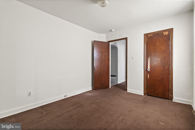 unfurnished bedroom featuring dark carpet