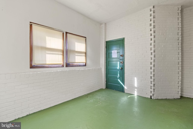 interior space with concrete flooring and brick wall