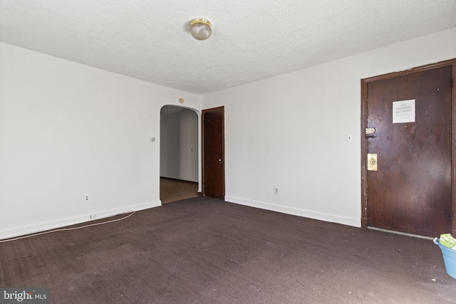 carpeted empty room with a textured ceiling