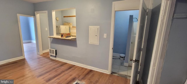 corridor with hardwood / wood-style flooring and electric panel