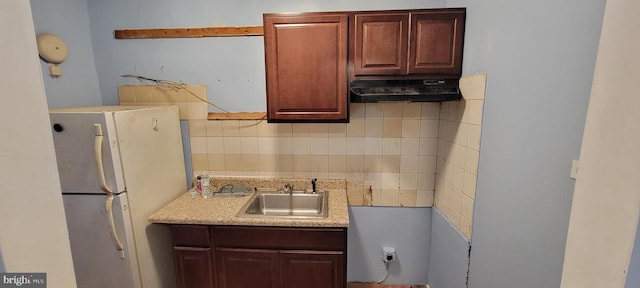 kitchen with white fridge, tasteful backsplash, and sink