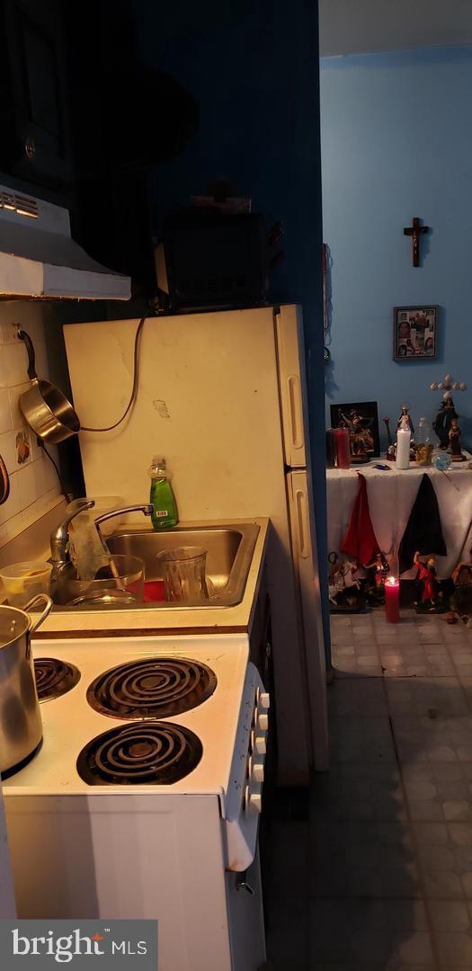 kitchen with white electric range oven, decorative backsplash, sink, and exhaust hood