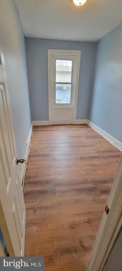 empty room featuring light hardwood / wood-style floors and a baseboard radiator