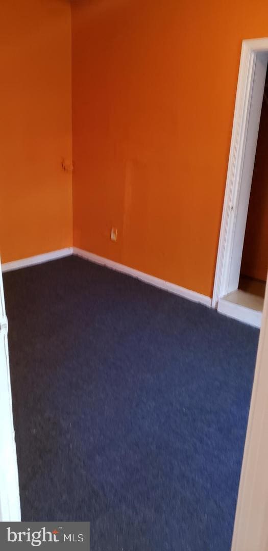 spare room featuring dark colored carpet