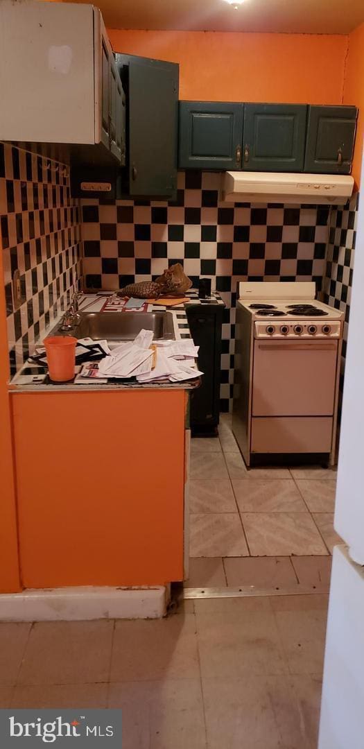 kitchen with decorative backsplash, light tile patterned flooring, and white range