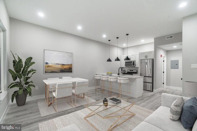 living room with sink and light hardwood / wood-style floors