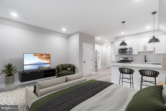 bedroom with light hardwood / wood-style floors and sink