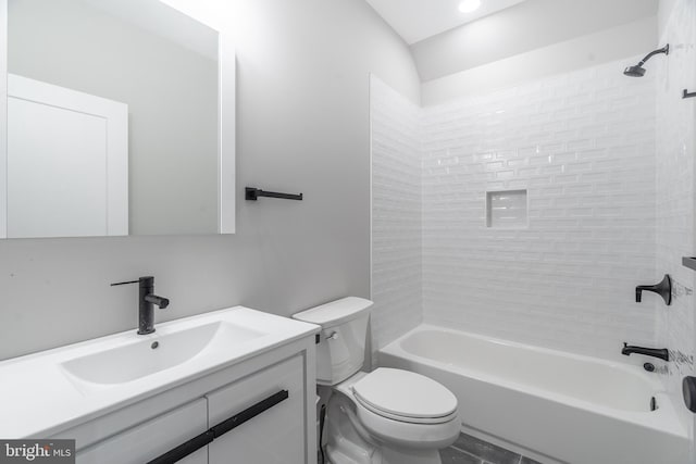 full bathroom featuring tiled shower / bath combo, vanity, tile floors, and toilet