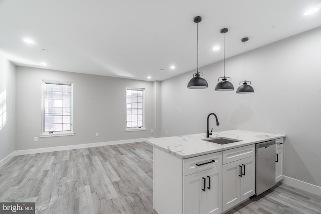 kitchen with sink, dishwasher, white cabinetry, decorative light fixtures, and light hardwood / wood-style flooring