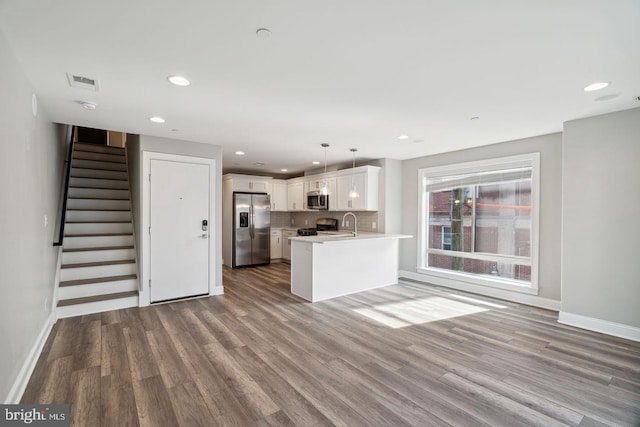 unfurnished living room with light wood-type flooring and sink