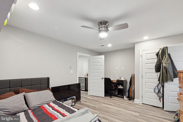 bedroom featuring wine cooler, ceiling fan, and light wood-type flooring