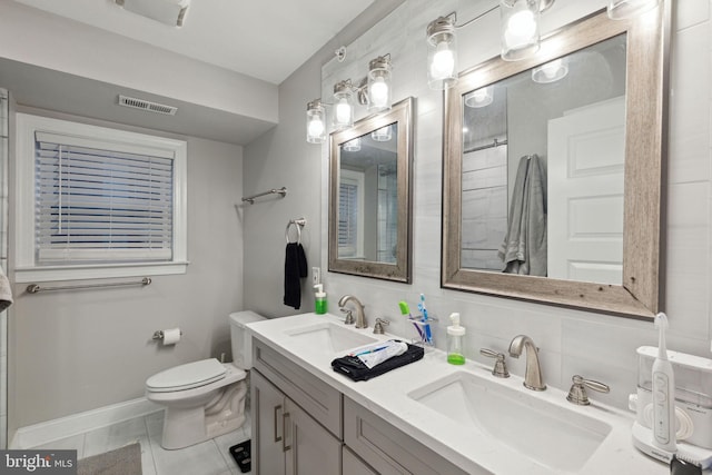 bathroom with tile patterned floors, vanity, toilet, and tasteful backsplash