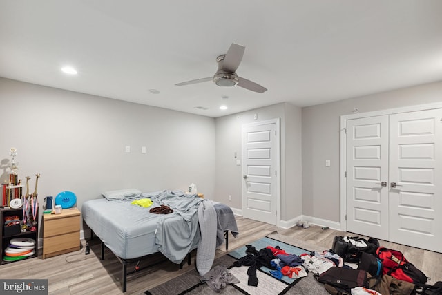 bedroom featuring ceiling fan, light hardwood / wood-style floors, and a closet