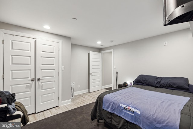 bedroom with light wood-type flooring and a closet