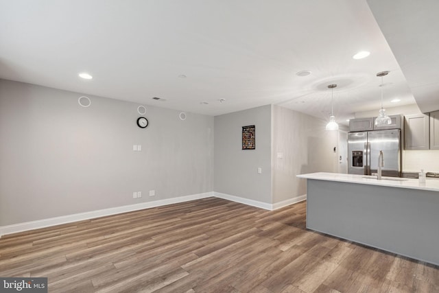 unfurnished living room with hardwood / wood-style flooring and sink