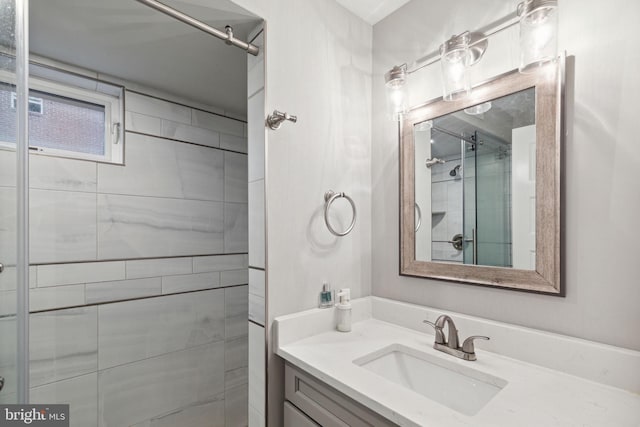 bathroom featuring a tile shower and vanity