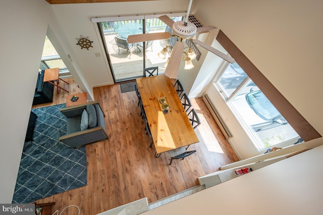 interior space with baseboard heating, ceiling fan, wood-type flooring, high vaulted ceiling, and beamed ceiling