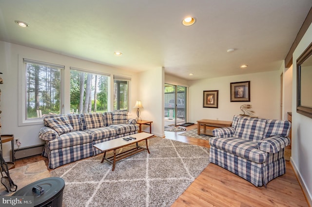 living room with wood-type flooring and a baseboard heating unit