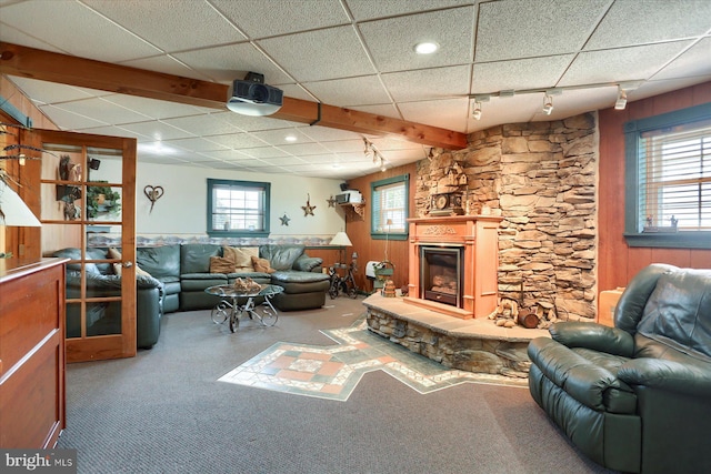 living room featuring a fireplace, plenty of natural light, a drop ceiling, and track lighting