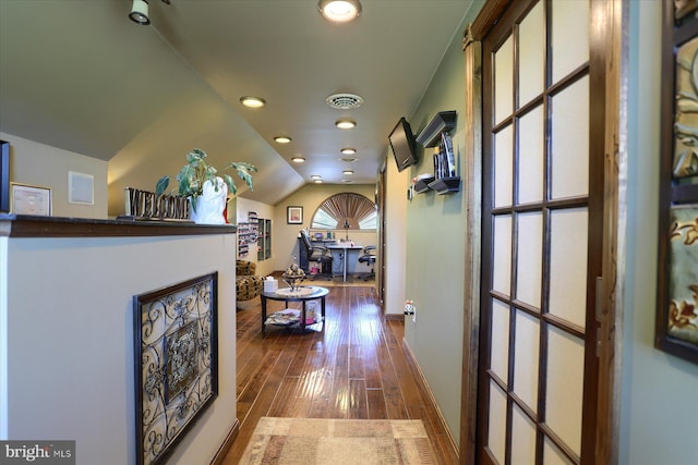 hall featuring hardwood / wood-style flooring and vaulted ceiling