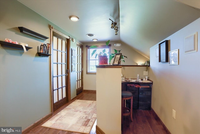 home office featuring wood-type flooring, track lighting, vaulted ceiling, and french doors