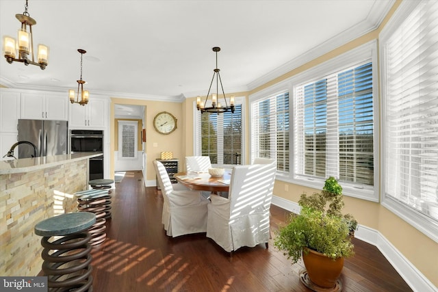 dining room featuring dark hardwood / wood-style floors, crown molding, and a chandelier