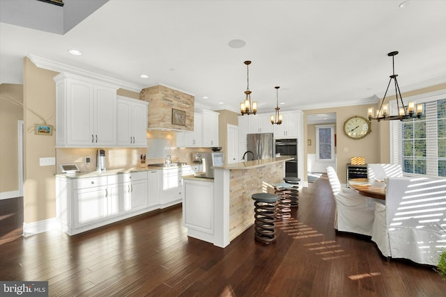 kitchen with pendant lighting, white cabinetry, stainless steel refrigerator, and a kitchen island