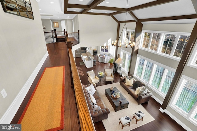 living room with beamed ceiling, dark hardwood / wood-style flooring, and an inviting chandelier