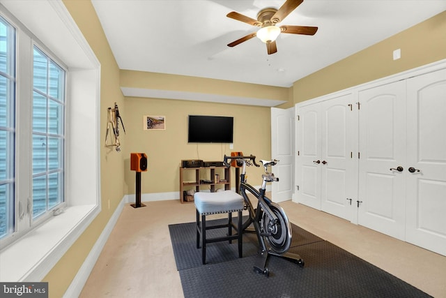 workout room featuring ceiling fan and light colored carpet