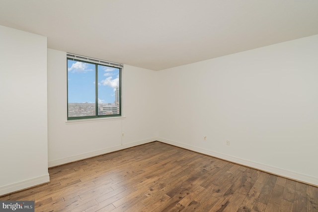 unfurnished room with dark hardwood / wood-style flooring